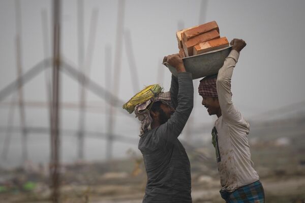 کارگران در حالی انتقال خشت ها در رودخانه برهماپوترا، گواهاتی هند. - اسپوتنیک ایران  