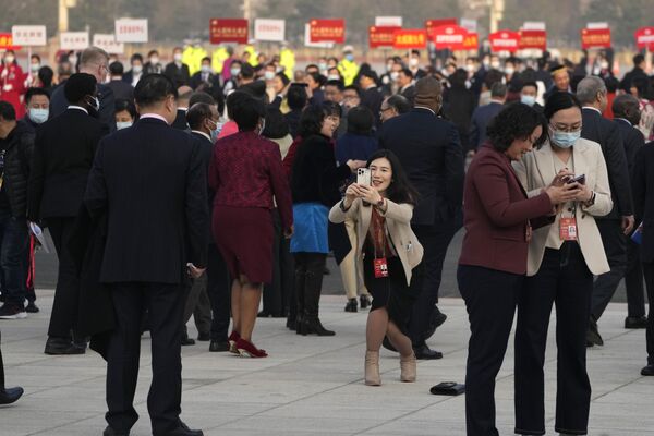 یکی از کارکنان پس از جلسه افتتاحیه کنگره مشورتی سیاسی خلق چین (CPPCC) در تالار بزرگ مردمی در پکن، شنبه، 4 مارس 2023، عکس می گیرد. (AP عکس از/Andy Wong) - اسپوتنیک ایران  