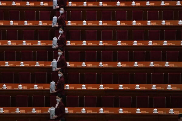 کارکنان قبل از جلسه افتتاحیه کنگره مشورتی سیاسی خلق چین (CPPCC) در تالار بزرگ مردم در پکن، شنبه، 4 مارس 2023، لیوان های آب را پر می کنند. (AP عکس از/Andy Wong) - اسپوتنیک ایران  