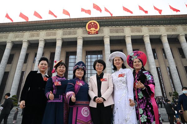 نمایندگان اقلیت های قومی پس از مراسم افتتاحیه کنفرانس مشورتی سیاسی خلق چین (CPPCC) در تالار بزرگ مردم در پکن در 4 مارس 2023 عکس می گیرند.(عکس از NOEL CELIS / AFP) - اسپوتنیک ایران  
