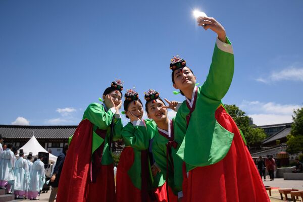 زنان جوانی که لباس سنتی هانبوک به تن دارند، در مراسم روز رسیدن به سن بلوغ در دهکده نمسان هانوک در سئول - اسپوتنیک ایران  