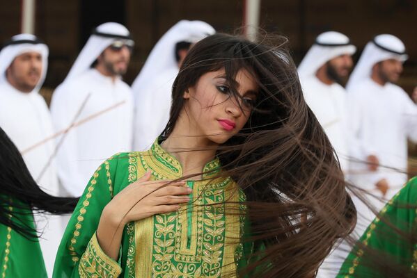 یک زن اماراتی در حال اجرای رقص سنتی در طول جشنواره شتر در میدان اسب دوانی سویهان در العین در حومه ابوظبی. - اسپوتنیک ایران  