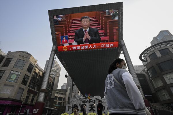 یک اکران بزرگ  در فضای باز پوشش خبری زنده از شی جین پینگ، رئیس جمهور چین را در طول جلسه افتتاحیه کنگره ملی خلق  در تالار بزرگ مردم نشان می دهد. - اسپوتنیک ایران  