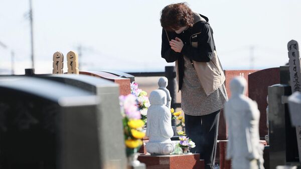 Женщина на  кладбище в городе Намие префектуры Фукусима в 12-ю годовщину землетрясения, вызвавшего цунами и ядерную катастрофу. - اسپوتنیک ایران  