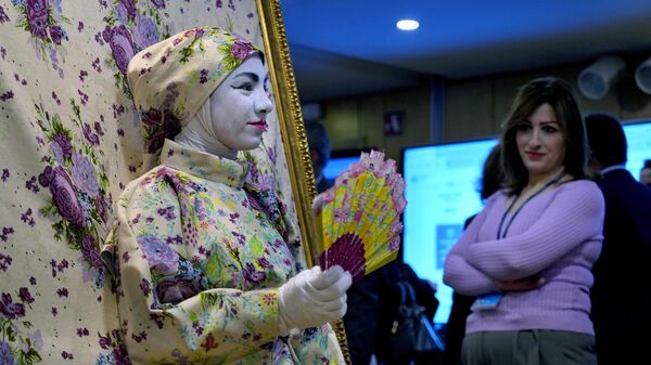 Посетительница смотрит на женщину, являющуюся частью интерактивной художественной инсталляции, во время Арабского форума по устойчивому развитию в Бейруте, Ливан - اسپوتنیک ایران  
