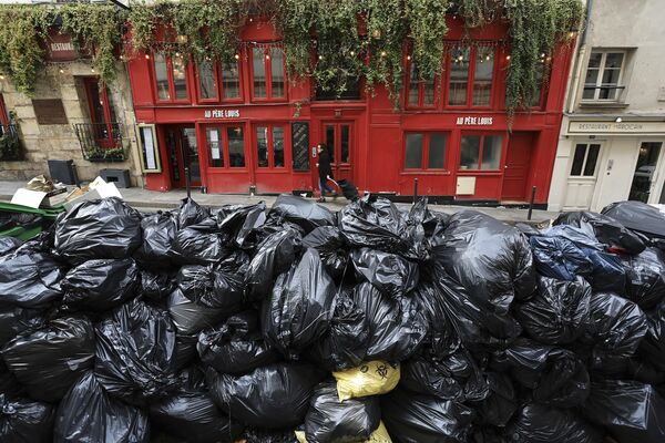 زباله های جمع آوری نشده در خیابانی در پاریس، 20 مارس 2023، در جریان اعتصاب  کارگران جمع آوری زباله  علیه اصلاحات حقوق بازنشستگی زباله ها در سطح شهر انباشته شده اند. - اسپوتنیک ایران  