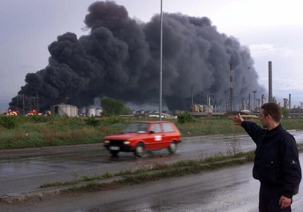 یک کارگر امنیتی یکشنبه، 18 آوریل 1999، به آتش زدن مخازن پالایشگاه نفت در پانچوو، حدود 16 کیلومتری (10 مایلی) شمال بلگراد اشاره می کند. رسانه های صربستان گفتند که بمب ها به یک پالایشگاه نفت در دومین شهر بزرگ یوگسلاوی، نووی ساد، و یک کارخانه کود نیتروژن و انبار ذخیره نفت در پانچوو در خارج از بلگراد اصابت کردند. - اسپوتنیک ایران  