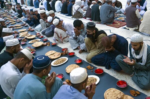  مسلمانان قبل از افطار در روز اول ماه مبارک رمضان در پیشاور در 23 مارس 2023 نماز می خوانند. - اسپوتنیک ایران  