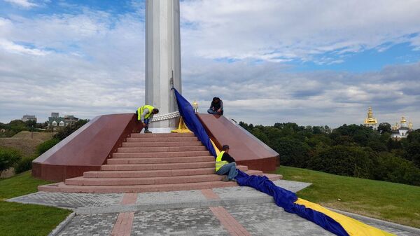 Сотрудники коммунальных служб снимают самый большой флаг Украины в Киеве - اسپوتنیک ایران  