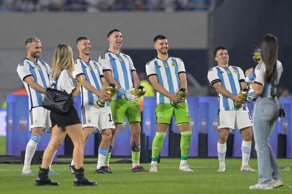 شوخی بازیکنان آرژانتین با کاپ های جام جهانی در مراسم قدردانی از تیم قهرمان جام جهانی، پس از بازی دوستانه فوتبال بین آرژانتین و پاناما، در استادیوم مونومنتال بوئنوس آیرس، در تاریخ 23 مارس 2023. - اسپوتنیک ایران  