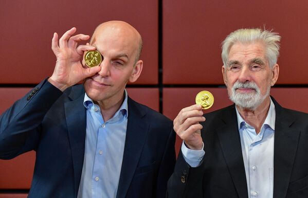 برندگان آلمانی جایزه نوبل فیزیک کلاوس هاسلمان  و جایزه نوبل شیمی بنجامین لیست  پس از شرکت در سمپوزیوم نوبل در سفارت سوئد در برلین، آلمان، در 7 دسامبر 2021، شوخی می کنند و با مدال های جایزه نوبل شکلاتی ژست می گیرند.  - اسپوتنیک ایران  