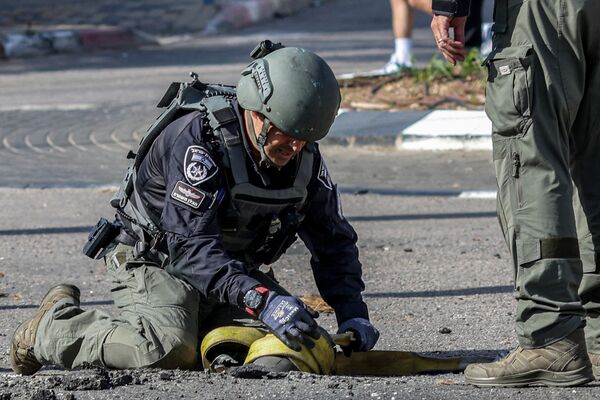 یکی از اعضای واحد خنثی سازی بمب پلیس اسرائیل بقایای گلوله ای را که از لبنان شلیک شده و توسط اسرائیل در شهر شلومی در شمال این کشور رهگیری شده بود، بازرسی می کند. - اسپوتنیک ایران  
