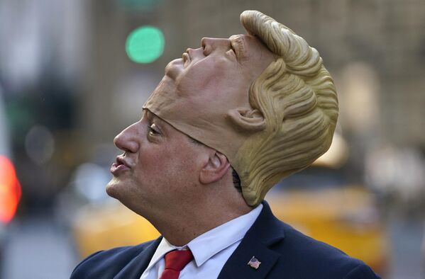 نیل گرینفیلد، شبیه دونالد ترامپ، در خارج از برج ترامپ در نیویورک در 12 اوریل 2023 منتظر است، زیرا جمعیت برای دیدن دونالد ترامپ، رئیس جمهور سابق ایالات متحده که قرار است امشب به شهر نیویورک بازگردد تا فردا در دفاتر منهتن ایالت نیویورک آماده شود. - اسپوتنیک ایران  