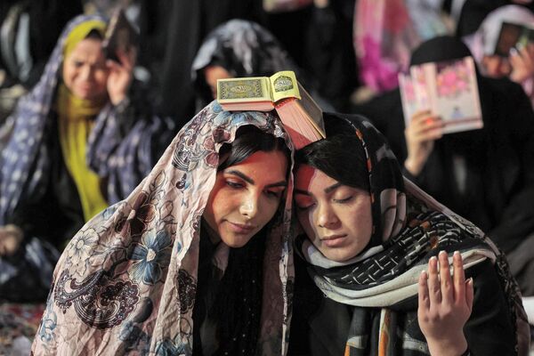 زنان مسلمان برای شرکت در نماز شب قدر (شب قدر) که یکی از مقدس ترین شب های ماه روزه مسلمانان در ماه مبارک رمضان است، در روز 10 آوریل 2023 در خارج از مسجد امامزاده صالح تهران گرد هم می آیند. - اسپوتنیک ایران  