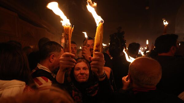 Православные христиане с зажженными свечами во время церемонии благодатного огня в храме Гроба Господня в Старом городе Иерусалима - اسپوتنیک ایران  