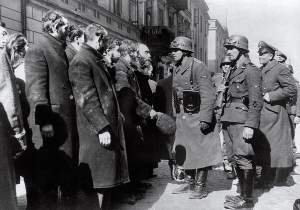 تصویری که در سال 1943 از سربازان آلمانی نازی در حال بازجویی از یهودیان پس از قیام گتوی ورشو گرفته شده است. - اسپوتنیک ایران  