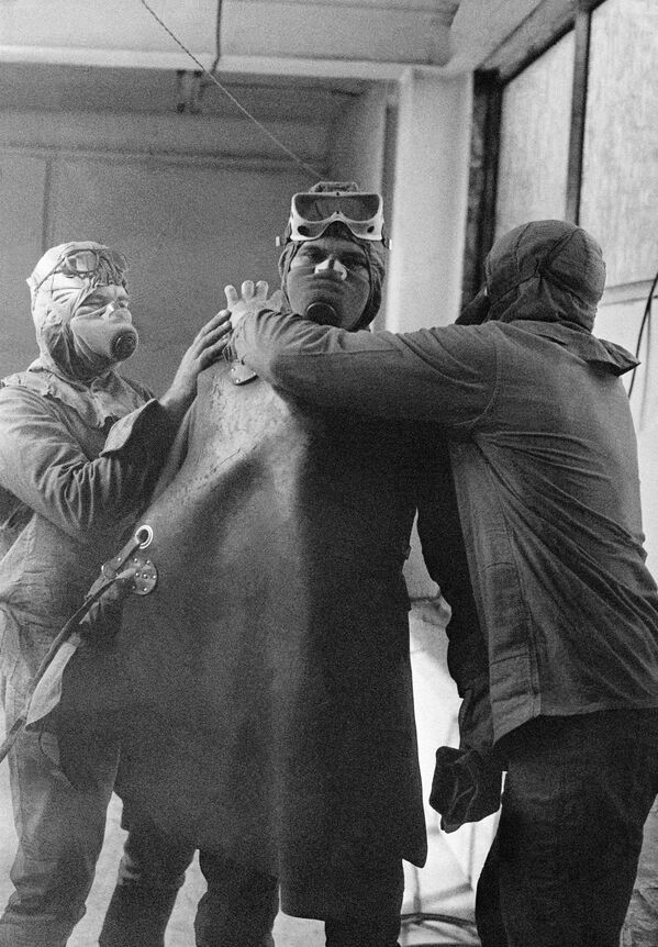 گروهی از داوطلبان در حال آماده شدن برای رفتن به پشت بام راکتور نیروگاه هسته‌ای چرنوبیل - اسپوتنیک ایران  