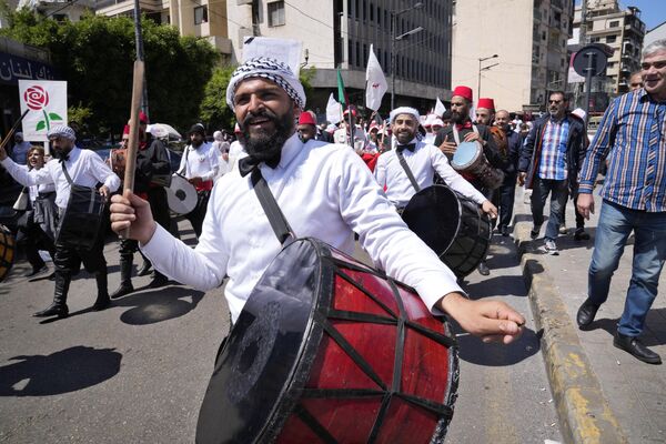 نوازندگان کوبه ای با پوشیدن لباس های سنتی لبنانی در راهپیمایی سالانه روز کارگر در بیروت. لبنان، دوشنبه، 1 مه 2023 - اسپوتنیک ایران  