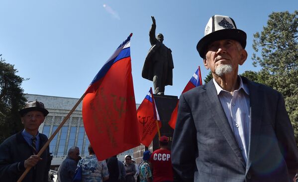 حامیان حزب کمونیست قرقیزستان پرچم‌های قرمز را در مقابل بنای یادبود ولادیمیر لنین بنیانگذار اتحاد جماهیر شوروی در دست دارند. بیشکک ،1 مه 2023. - اسپوتنیک ایران  