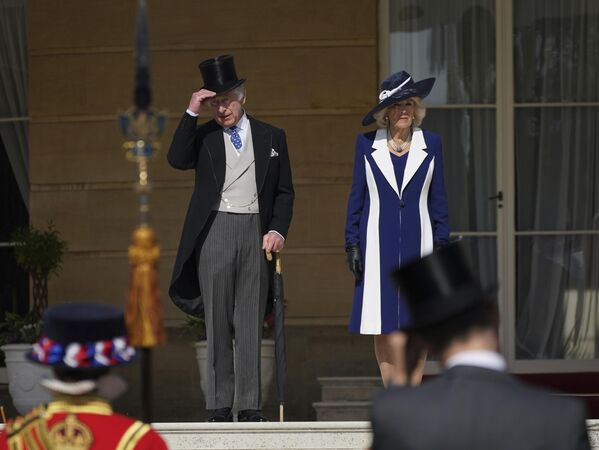 پادشاه بریتانیا چارلز سوم و کامیلا، همسر ملکه، در جشن تاج‌گذاری در روز 6 می، در پارتی باغ در کاخ باکینگهام لندن، در روز چهارشنبه 3 می 2023، روی پله‌ها ایستاده‌اند. - اسپوتنیک ایران  