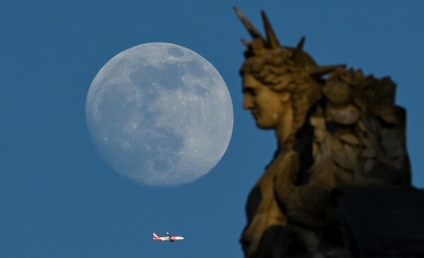 با طلوع ماه غول‌پیکر در پاریس، در 3 می 2023، یک هواپیما از کنار مجسمه لوور پرواز می‌کند. - اسپوتنیک ایران  