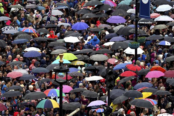 جمعیت نزدیک میدان ترافالگار پیش از مراسم تاجگذاری پادشاه چارلز سوم در کلیسای وست مینستر لندن، شنبه 6 مه 2023، از باران پناه می برند. (گرت فولر/عکس از استخر از طریق AP) - اسپوتنیک ایران  