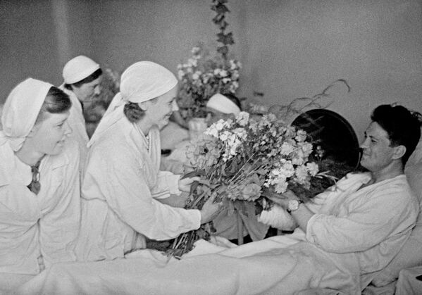 جنگ بزرگ میهنی 1941-1945. پرستاران به مجروحان  در بیمارستان مسکو گل هدیه می کنند. - اسپوتنیک ایران  