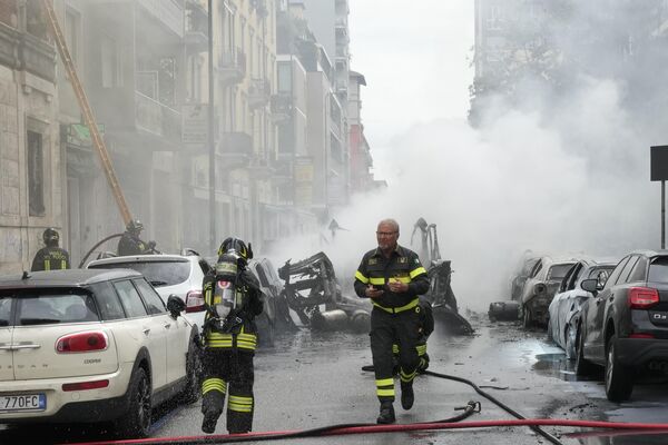 آتش نشانان برای خاموش کردن آتش سوزی در یک ساختمان پس از انفجار یک ون در مرکز میلان، شمال ایتالیا، پنجشنبه 11 مه 2023 تلاش می کنند. (AP Photo/Luca Bruno) - اسپوتنیک ایران  