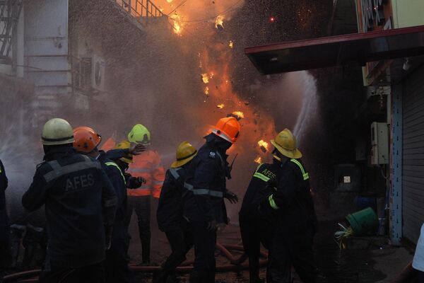 آتش‌نشانان در 10 مه 2023 در یک ردیف خانه‌های مسکونی در احمدآباد تلاش می‌کنند آتش را خاموش کنند. (عکس از سام پانتاکی / خبرگزاری فرانسه) - اسپوتنیک ایران  