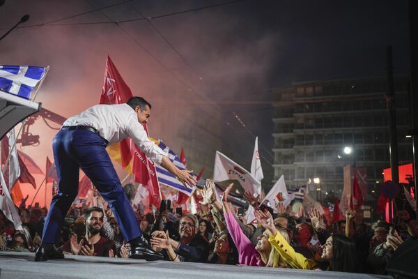 الکسیس سیپراس، رهبر حزب اصلی اپوزیسیون یونان سیریزا، در جریان تظاهرات پیش از انتخابات در آتن با هواداران خود دست می دهد. - اسپوتنیک ایران  