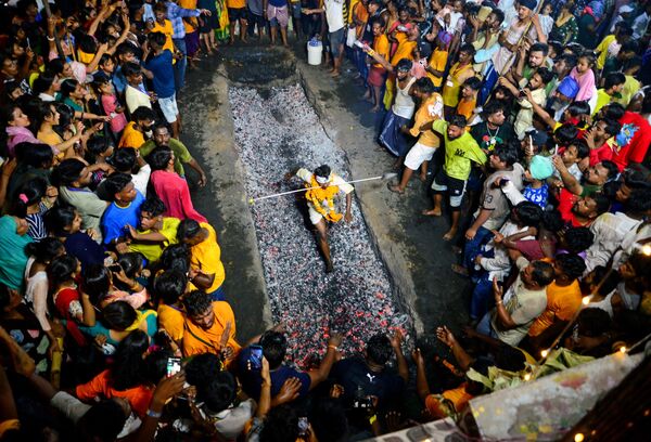 در این تصویر که در 14 مه 2023 گرفته شده است، یک  هندو در جشنواره Maa Maariamma Mela در جالاندهار  هند روی ذغال سوزان می دود. - اسپوتنیک ایران  
