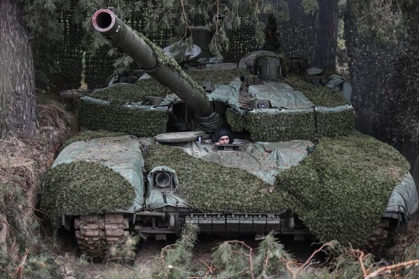 یکی از خدمه نوع مدرنیزه شده تانک &quot;تی ـ 90&quot;  در بخش جنوبی  عملیات ویژه نظامی روسیه در اوکراین آنرا بررسی می کند - اسپوتنیک ایران  