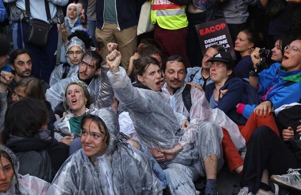 معترضان به اقلیم مشت خود را بالا می برند در حالی که درگیری بین پلیس و معترضان با استفاده از گاز اشک آور در جریان تظاهراتی در حومه محل پاریس برای نشست عمومی سالانه TotalEnergies در پاریس در 26 مه 2023 آغاز شد. غول نفت و گاز فرانسه در حال آماده شدن است. برای یک نشست الکتریکی، هدف ائتلافی از انجمن ها که تهدید به مسدود کردن آن می کنند، اما همچنین توسط برخی از سهامداران آن که با سیاست آب و هوایی آن مخالف هستند. (عکس از جفروی ون در هاسلت / خبرگزاری فرانسه) - اسپوتنیک ایران  