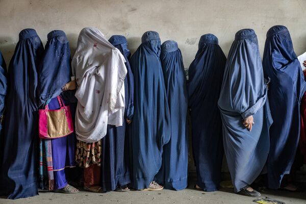 زنان افغان در انتظار دریافت جیره غذایی توزیع شده توسط یک گروه کمک های بشردوستانه در کابل، افغانستان، سه شنبه، 23 می 2023 هستند. (عکس آسوشیتدپرس/ ابراهیم نوروزی) - اسپوتنیک ایران  