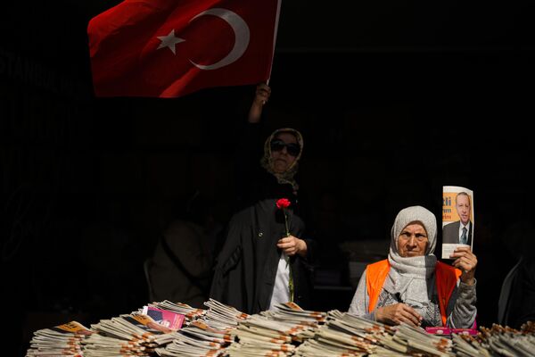 حامیان رجب طیب اردوغان، رئیس‌جمهور ترکیه و نامزد ریاست‌جمهوری ائتلاف مردمی، سه‌شنبه، 23 مه 2023، به مسافران در استانبول، ترکیه اعلامیه‌هایی می‌دهند. رای‌دهندگان در ترکیه پس از اینکه نه اردوغان و نه رقیبش، برای دور دوم انتخابات در 28 مه به پای صندوق‌های رای خواهند رفت. کمال کیلیچداراوغلو در دور اول روز یکشنبه بیش از 50 درصد آرا را به دست آورد. (AP Photo/Francisco Seco) - اسپوتنیک ایران  