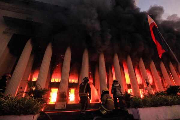 آتش نشانان آتش سوزی در ساختمان اداره پست در مانیل را در 22 مه 2023 خاموش کردند. (عکس از خبرگزاری فرانسه) - اسپوتنیک ایران  