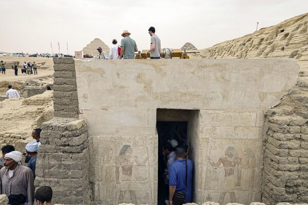 بازدید مردم از یک مقبره باستانی تازه کشف شده در گورستان ساقارا در جنوب قاهره، جایی که باستان شناسان دو کارگاه مومیایی کردن انسان و حیوانات و همچنین دو مقبره را کشف کردند. - اسپوتنیک ایران  