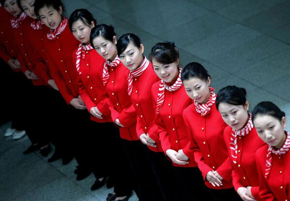 خدمه پرواز از گروه هوانوردی چین گانگتونگ در طی مراسمی برای تبلیغ شرکت هواپیمایی مستقر در هنگ کنگ در پکن، 29 مه 2006 عکس می گیرند. خطوط هوایی چین در سه ماهه اول سال 2006 مجموعاً 2.14 میلیارد یوان (267 میلیون دلار) به دلیل سوخت بالای جت ضرر کرده اند. قیمت‌ها، و اگرچه بازار سفرهای هوایی چین در حال رونق است، با تعداد مسافران، و همچنین ترافیک محموله‌ها و پست‌ها که انتظار می‌رود تا سال 2010 نسبت به سال گذشته دو برابر شود، خطوط هوایی همچنان متحمل ضررهای عمده می‌شوند. AFP PHOTO (عکس از AFP / AFP) - اسپوتنیک ایران  