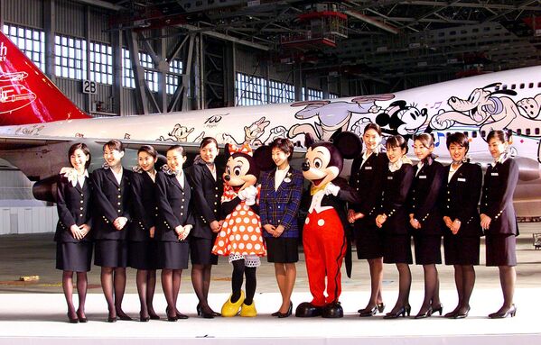خدمه پرواز خطوط هوایی ژاپن (JAL) با شخصیت‌های میکی و مینی ماوس قبل از جت جامبو جت JAL طراحی شده با شخصیت دیزنی، در یک پیش‌نمایش مطبوعاتی در آشیانه فرودگاه بین‌المللی توکیو در هاندا، 29 ژانویه 2001، عکس می‌گیرند. JAL خدمات خود را آغاز خواهد کرد. با هواپیمای جدید طراحی شده &quot;Dream Express&quot; از 30 ژانویه به مناسبت پنجاهمین سالگرد تاسیس این شرکت هواپیمایی. AFP PHOTO/Yoshikazu TSUNO (عکس از YOSHIKAZU TSUNO / AFP) - اسپوتنیک ایران  