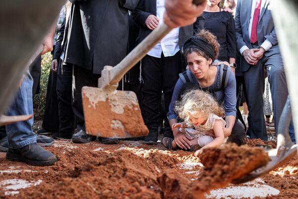  همسر میر تاماری، شهرک نشین 32 ساله اسرائیلی که  به ضرب گلوله کشته شد،  هنگام خاکسپاری وی در گورستان منطقه ای شاکد در شمال کرانه باختری اشغالی، در کنار قبر عزاداری می کند. - اسپوتنیک ایران  