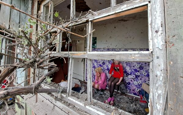 ساکنان خانه ای در گورلووکا، جمهوری خلق دونتسک، که از گلوله باران توسط نیروهای مسلح اوکراین آسیب دیده است. در نتیجه این گلوله باران یک مرد کشته شد. - اسپوتنیک ایران  