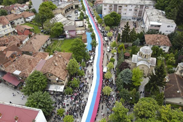 مردم یک پرچم عظیم  صربستان را در جریان تظاهراتی در شهر زوکان در شمال کوزوو، چهارشنبه، 31 مه 2023 در دست دارند. - اسپوتنیک ایران  