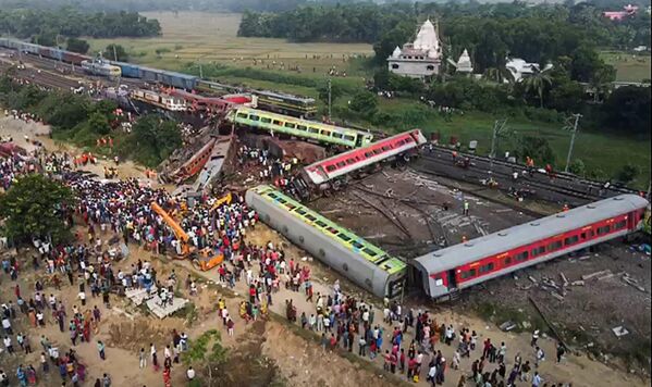 این تصویربرداری از صفحه نمایش گرفته شده از فیلم ویدئویی AFPTV که در 3 ژوئن 2023 گرفته شده است، مردم را نشان می دهد که در محل حادثه برخورد سه قطار در نزدیکی بالاسوره، حدود 200 کیلومتر (125 مایل) از مرکز ایالت بوبانسوار در ایالت شرقی اودیشا جمع شده اند. مقامات هند در سوم ژوئن اعلام کردند که مرگبارترین حادثه ریلی در بیش از 20 سال گذشته در هند، حداقل 288 نفر کشته و بیش از 850 نفر زخمی شدند. (عکس توسط Jayanta SHAW / AFPTV / AFP) - اسپوتنیک ایران  