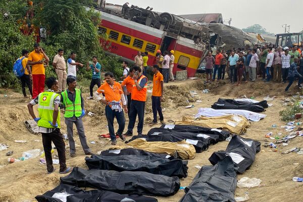 توجه سردبیران: محتوای گرافیکی / کارکنان پزشکی در مقابل اجساد قربانیانی که در تصادف پس از برخورد سه قطار در نزدیکی بالاسور، حدود 200 کیلومتر (125 مایل) از پایتخت ایالت بوبانشوار، در 3 ژوئن 2023 کشته شدند، ایستاده اند. حداقل حداقل مقامات محلی هند گفتند که در اثر برخورد هولناک سه قطار در اواخر 2 ژوئن در ایالت اودیشا در شرق هند، 207 نفر کشته، بیش از 850 نفر دیگر زخمی شدند و بیم آن می رود که بسیاری دیگر به دام افتاده باشند. (عکس از دیبیانگشو سرکار / خبرگزاری فرانسه) - اسپوتنیک ایران  