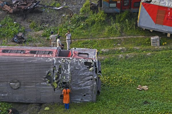 پلیس واگنهای شکسته برخورد سه قطار در نزدیکی بالاسوره، در ایالت شرقی اودیشا هند، در 4 ژوئن 2023 را بازرسی میکند. پلیس واگنهای شکسته برخورد سه قطار در نزدیکی بالاسوره، در ایالت شرقی اودیشا هند، در 4 ژوئن 2023 را بازرسی میکند. - اسپوتنیک ایران