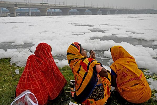 زنان در آستانه روز جهانی محیط زیست در دهلی نو بعد از حمام در آب های آلوده رودخانه یامونا مملو از کف، دعا می خوانند. - اسپوتنیک ایران  