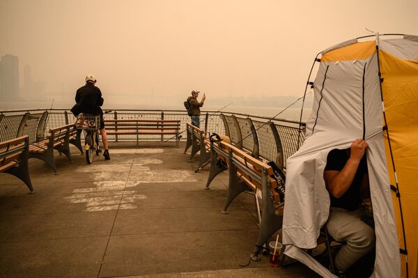 مردم از اسکای لاین منهتن عکس می گیرند.  دود ناشی از آتش سوزی های جنگلی در کانادا باعث ایجاد شرایط مه آلود در شهر نیویورک شده است. چهارشنبه، 7 ژوئن 2023 - اسپوتنیک ایران  