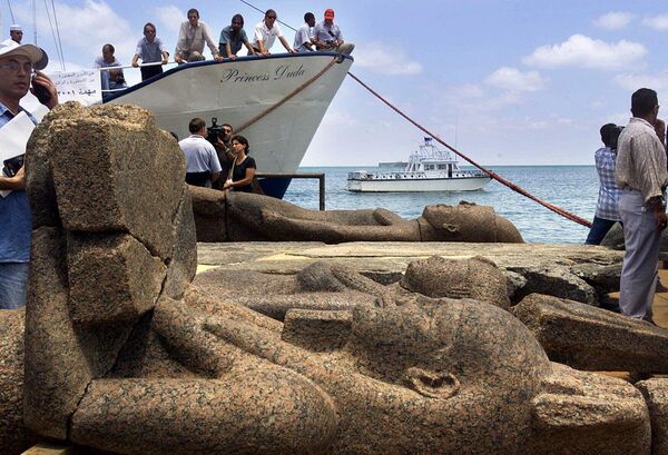 مجسمه بزرگ خدای هاپی و دو مجسمه ناشناس دیگر از شهر غرق شده هراکلیون از  روی عرشه یک قایق در شهر  اسکندریه،مصر پس از اینکه یک تیم باستان‌شناسی زیر آبی فرانسوی آنها را همراه با اشیای گرانبهای دیگر به سطح آب بردند، تخلیه می شوند. بیش از 1000 سال پیش وقوع زلزله، شهر فرعونی هراکلیون را به قعر دریای مدیترانه فرستاد. - اسپوتنیک ایران  