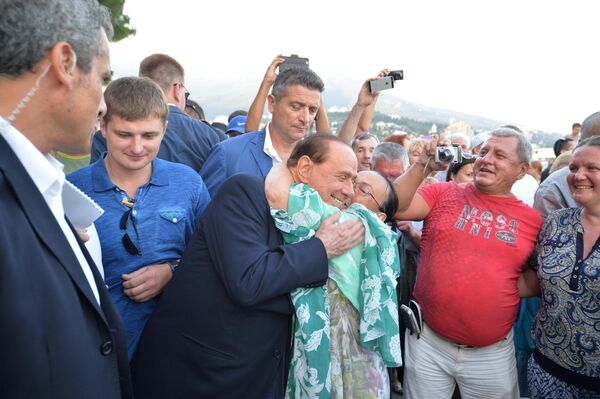  سیلویو برلوسکونی، نخست وزیر سابق ایتالیا (در مرکز) در حالی که با رئیس جمهور روسیه در پارک ساحلی یالتا در کریمه قدم می زند با ساکنان محلی صحبت می کند.ابراز احسااست یکی از شهروندان نسبت به برلوسکونی او را شاد کرده است. - اسپوتنیک ایران  
