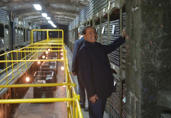 سیلویو برلوسکونی، نخست وزیر سابق ایتالیا، به همراه ولادیمیر پوتین، رئیس جمهور روسیه، در انبار اصلی زیرزمینی انجمن ماساندرا که بزرگترین کتابخانه شراب در جهان به حساب می آید. سال 2015 میلادی. - اسپوتنیک ایران  